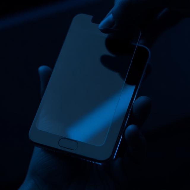 Premium tempered glass screen protector with crystal clear coating displayed against a gradient blue background